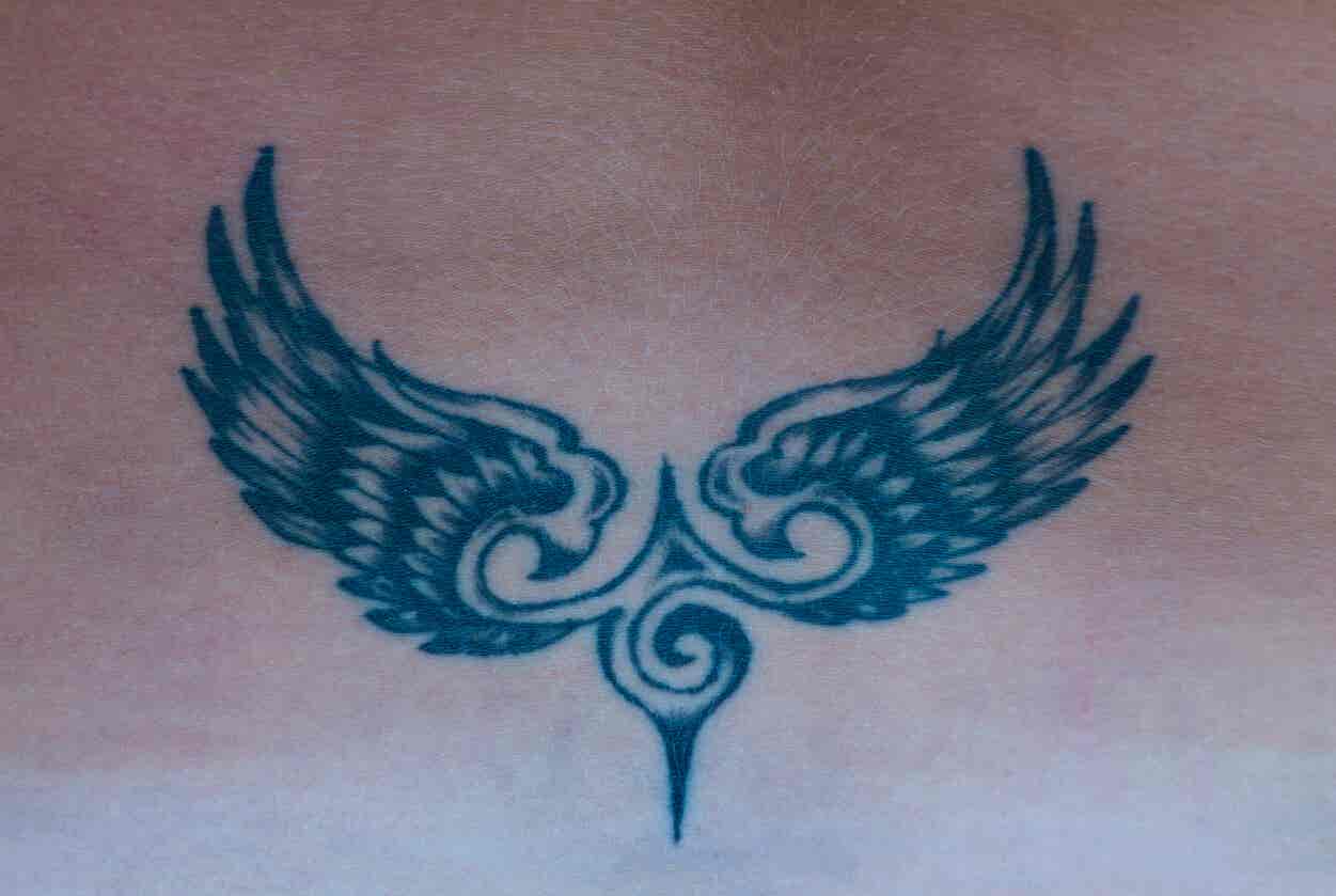 Tatuaje simbólico de águila y alas.