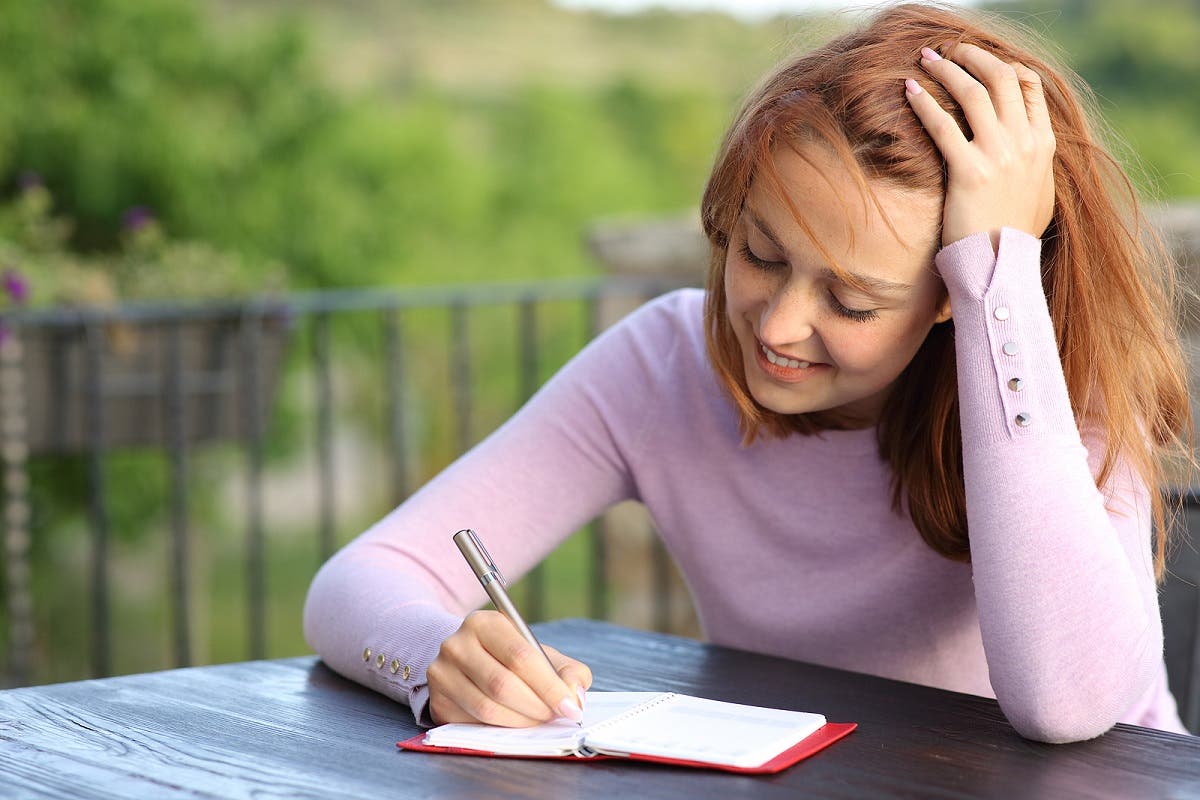 La femme écrit un ordre du jour pour organiser le temps.