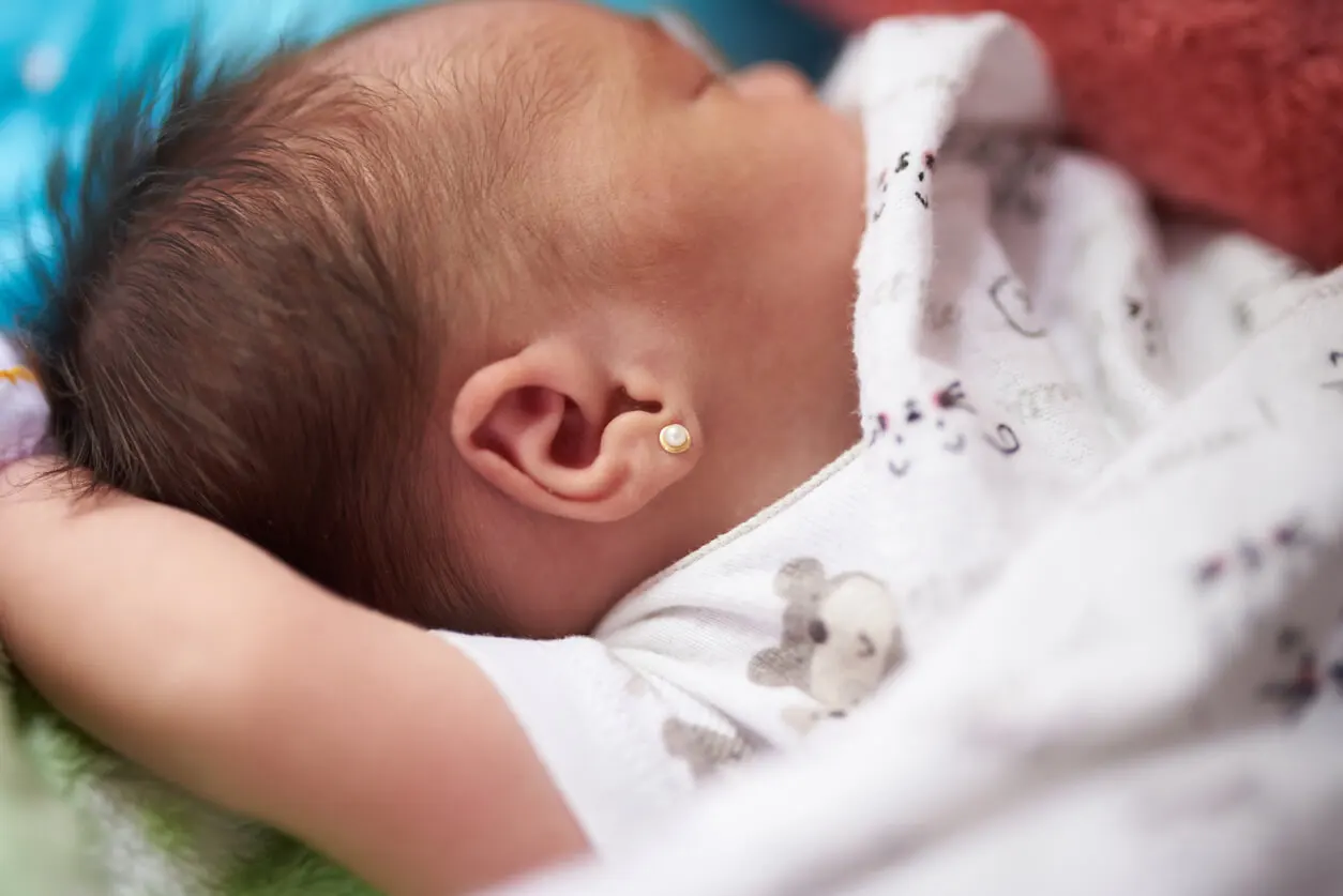 Aretes en las orejas de una bebé.