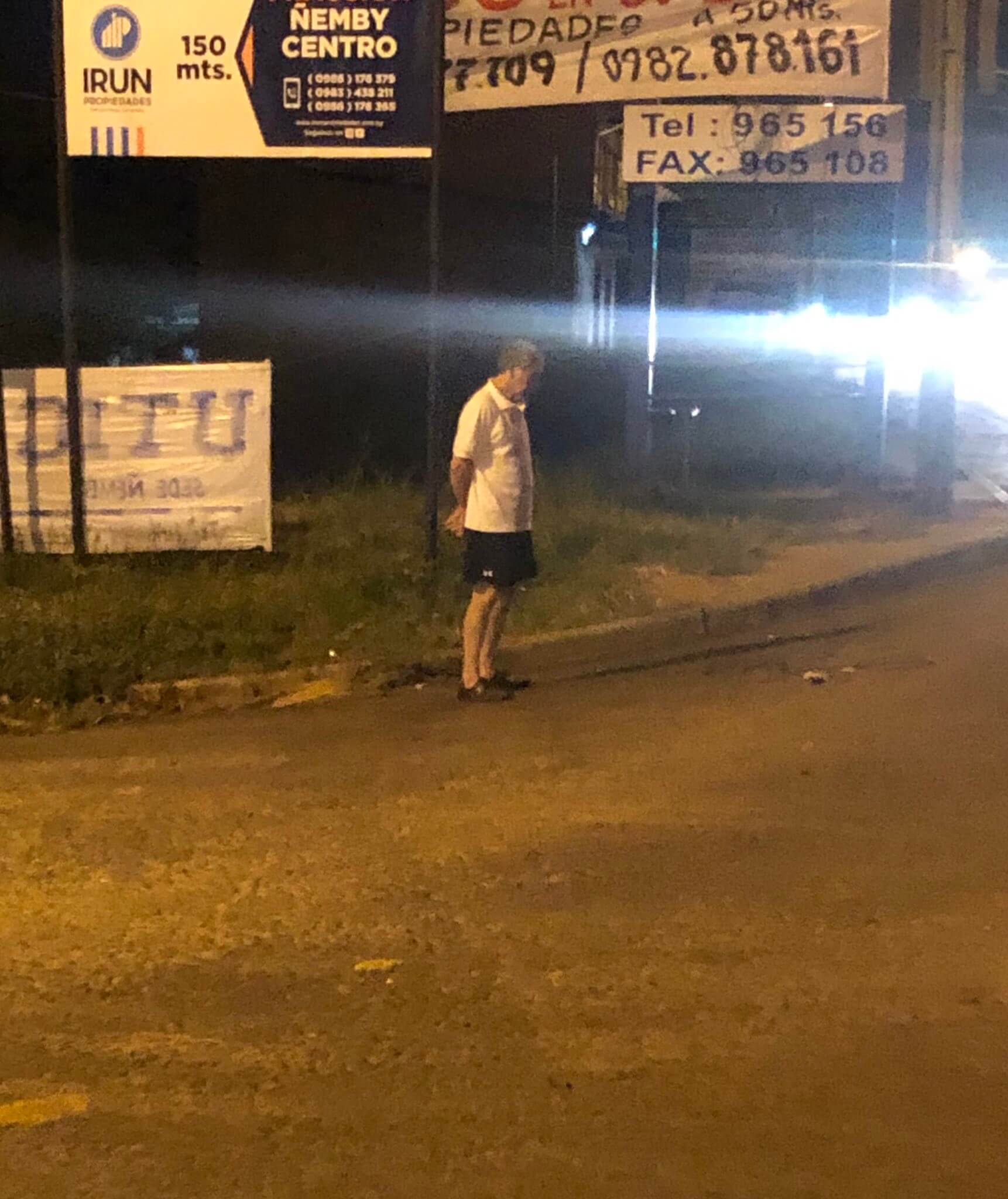 El señor esperando en la parada del bus.