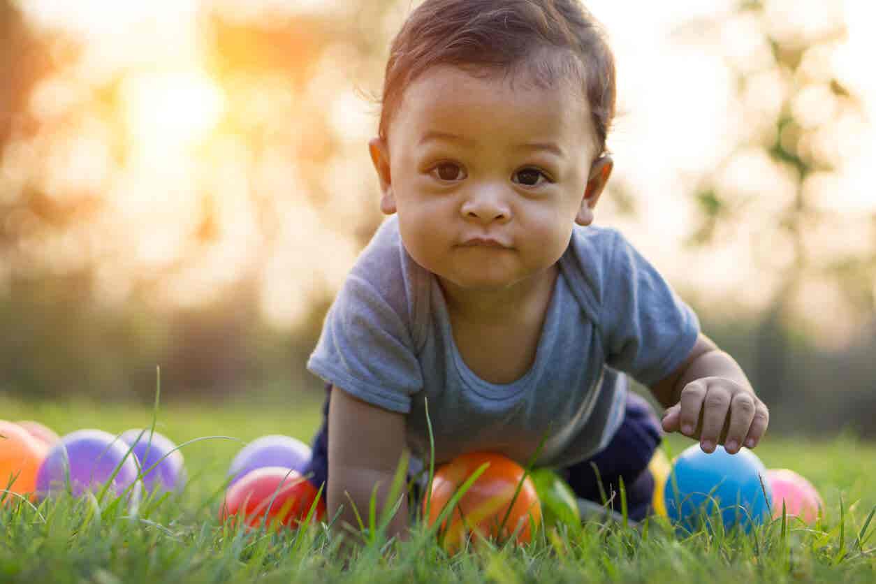 Der absorbierende Geist - Kleinkind mit Bällen auf einem Rasen