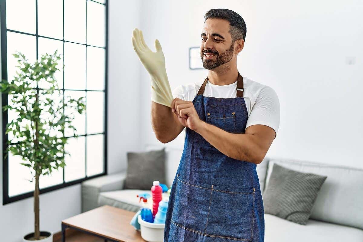 L'homme met des gants de ménage