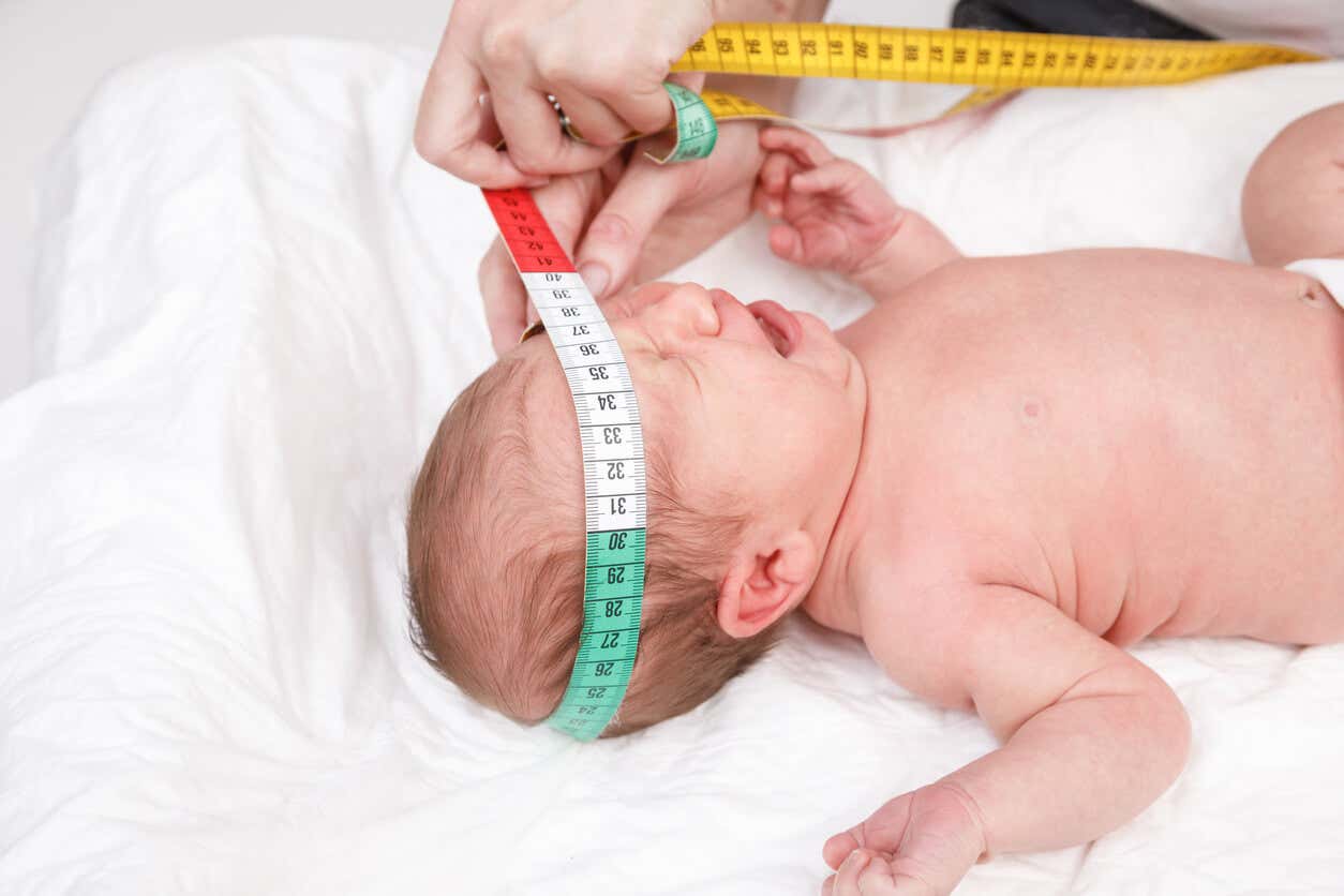4 Monate alte Babys - Person misst den Kopfumfang eines Babys