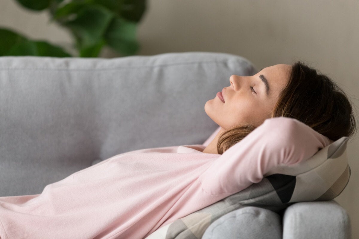 Ungewissheit ertragen - Frau entspannt auf dem Sofa