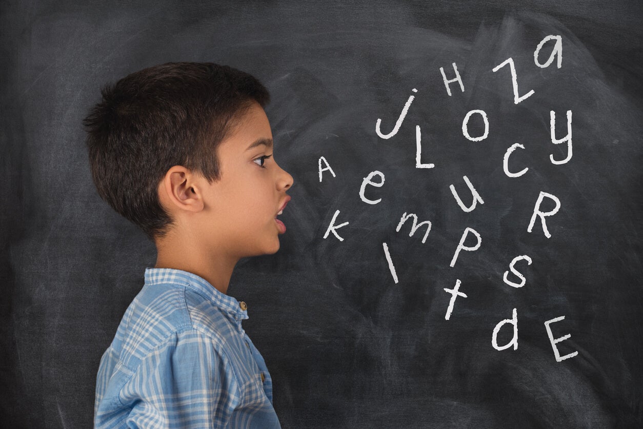 Sprachphilosophie - Kind vor einer Tafel mit Buchstaben