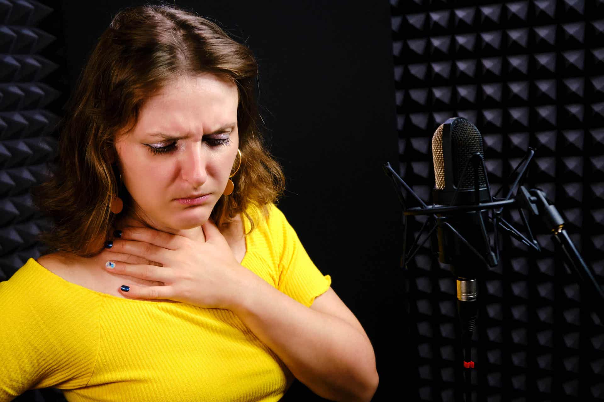 Femme qui a mal a la gorge au moment de chanter. 