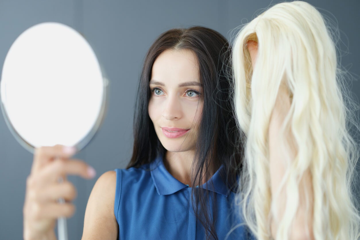 Echthaarperücke - Frau mit einer Perücke vor dem Spiegel