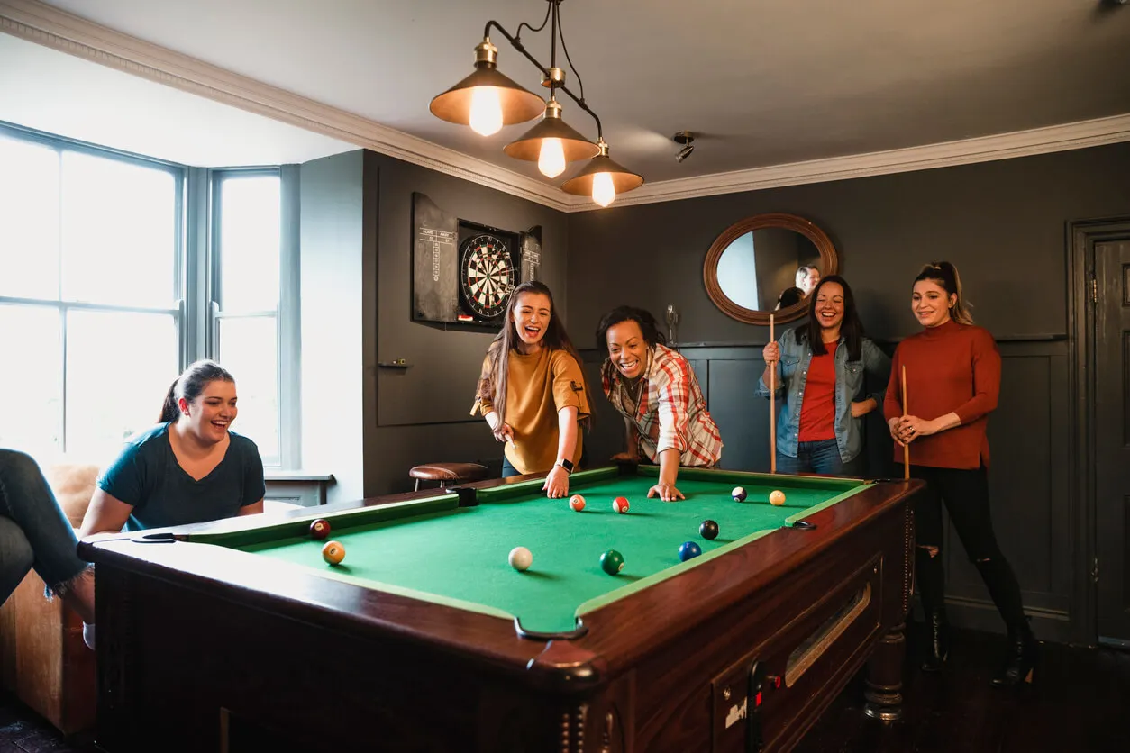 Des amis jouent au billard.