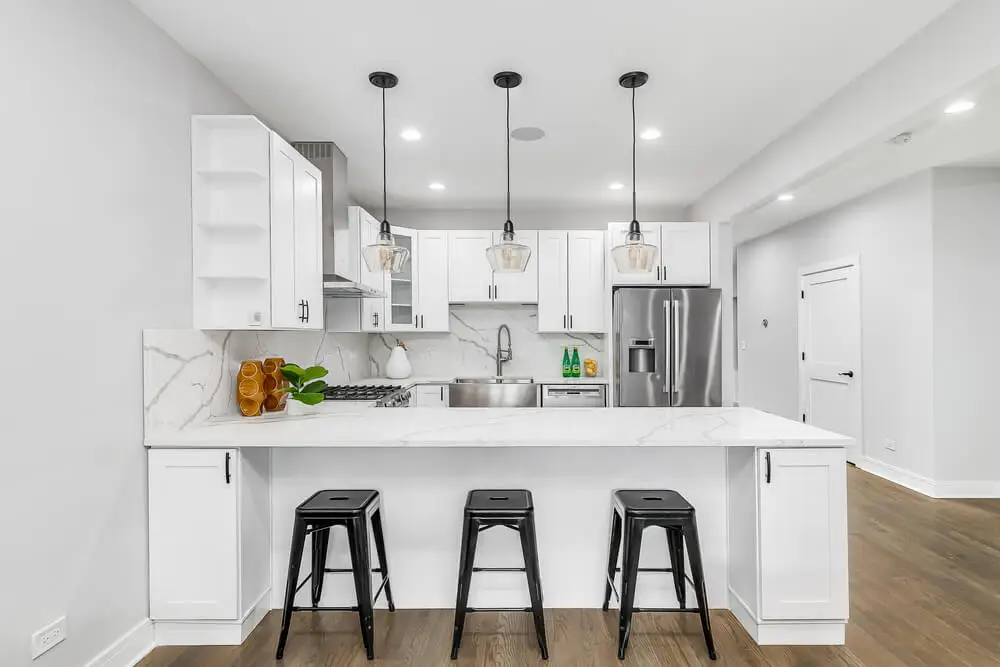 Cocina en blanco con barra blanca.