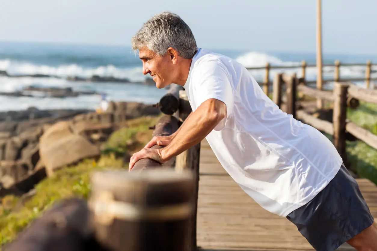 Hombre mayor hace flexiones para su fuerza muscular.
