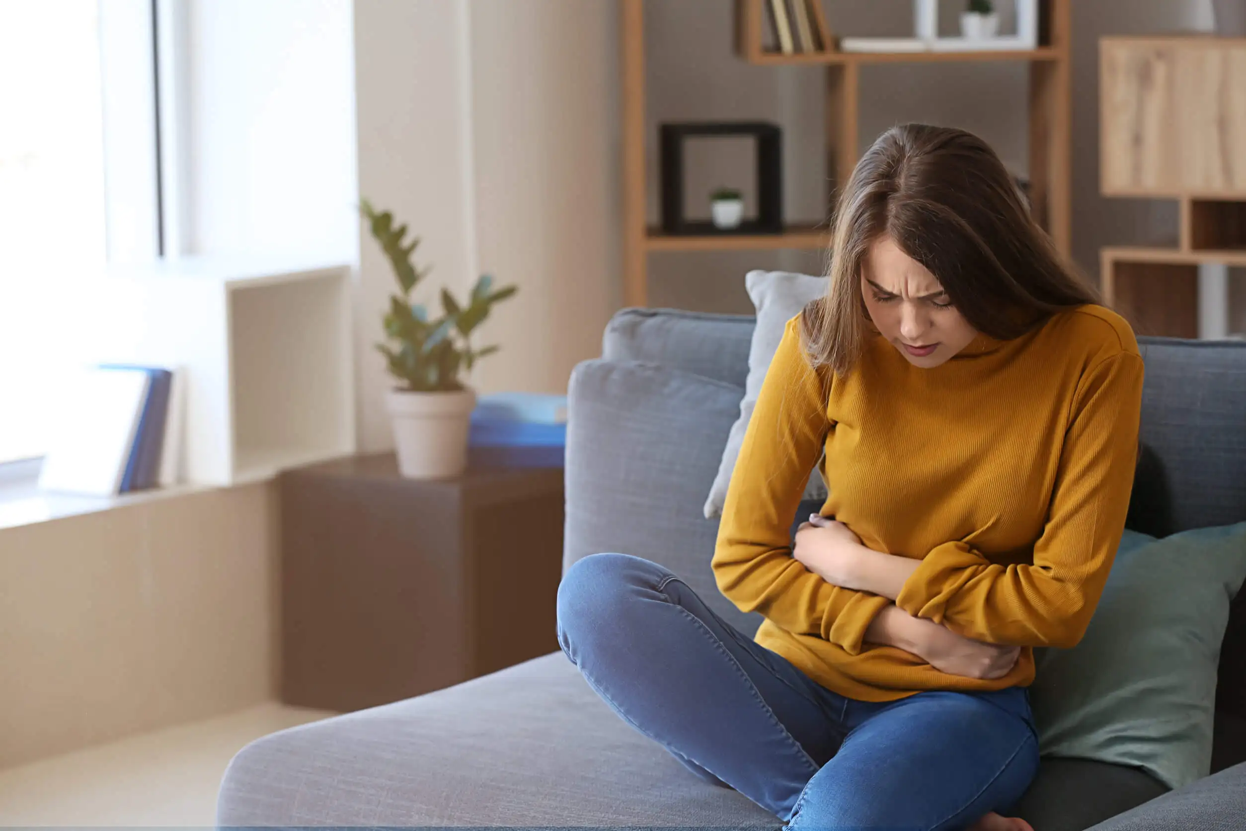 Mujer con dolor abdominal en casa.