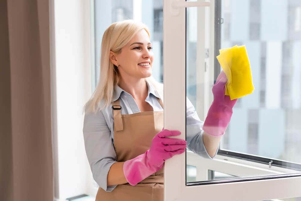 Mujer limpiando la ventana.
