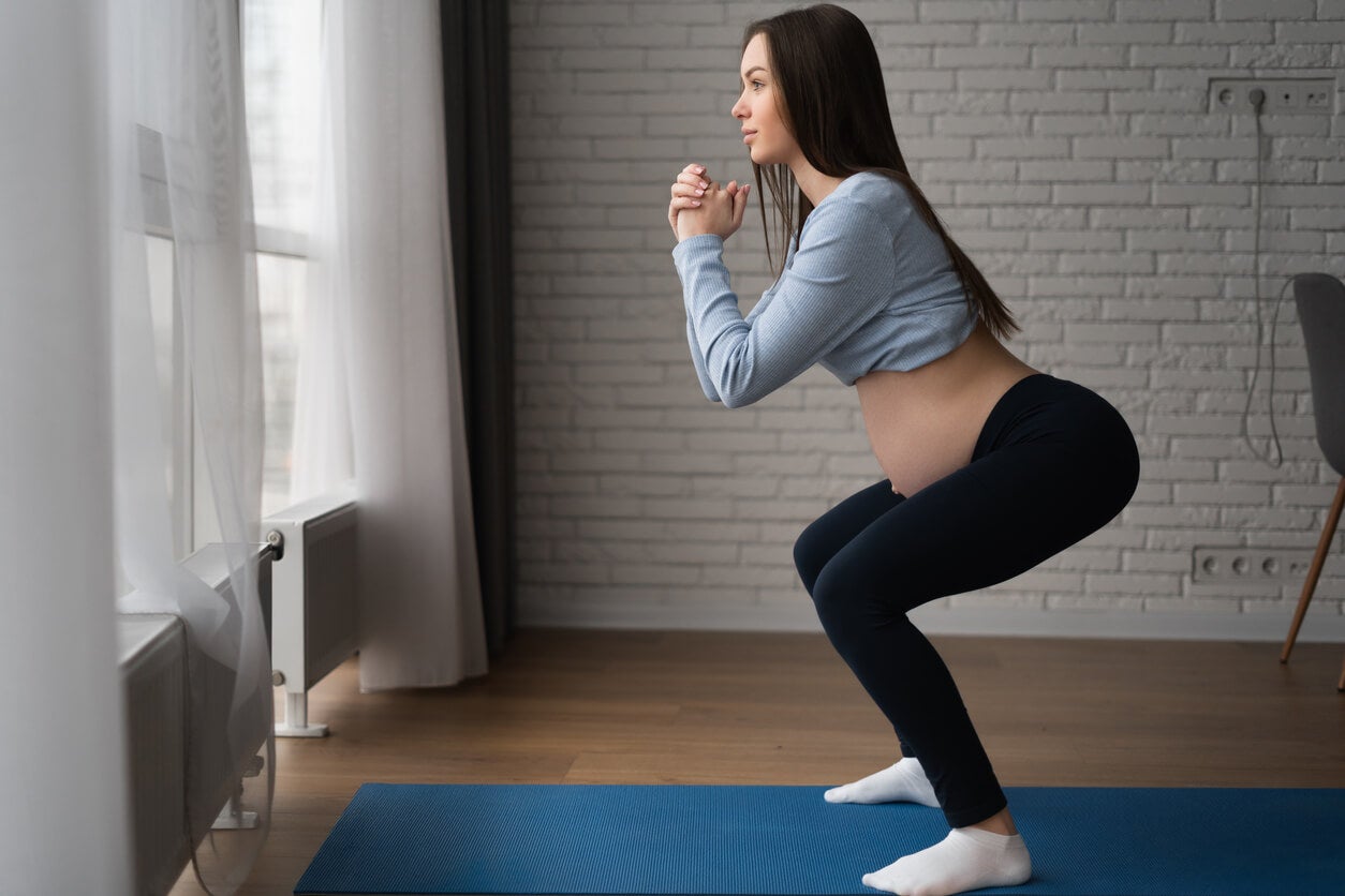 Une femme enceinte qui fait des squats.