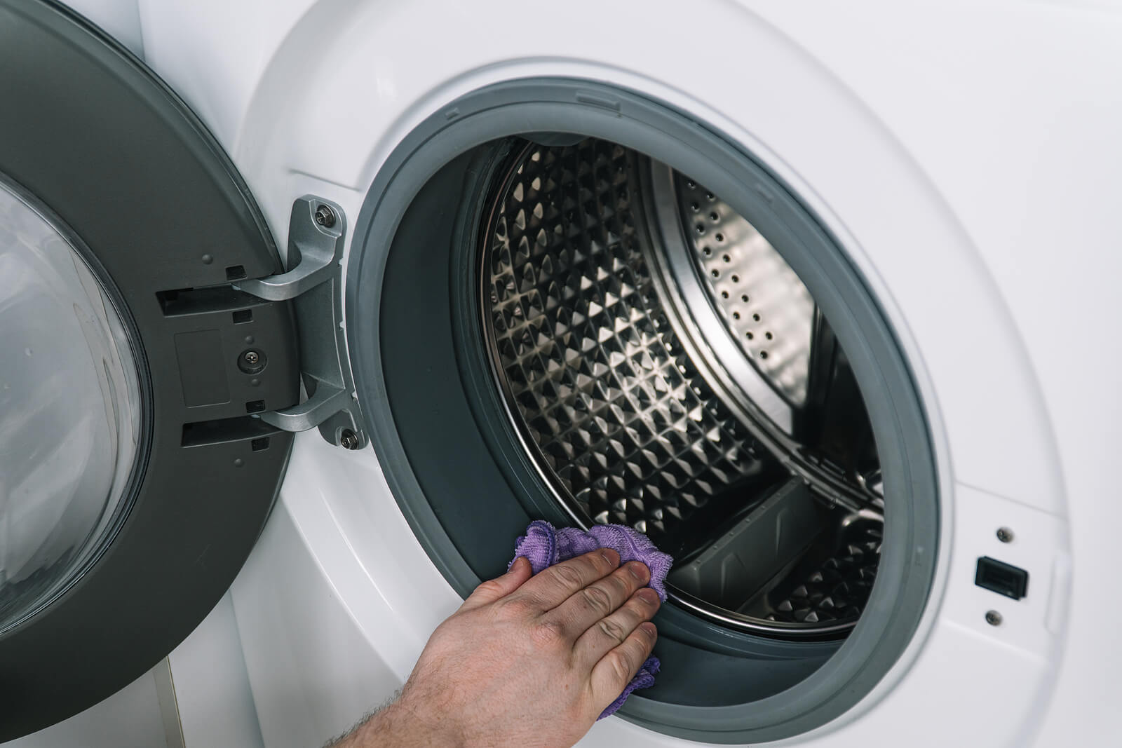 Removing lint from the washing machine.
