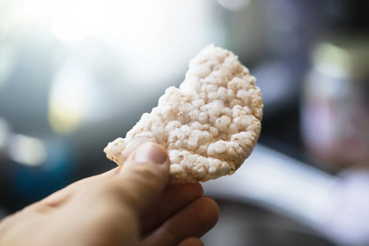 Mão segura panquecas de arroz.