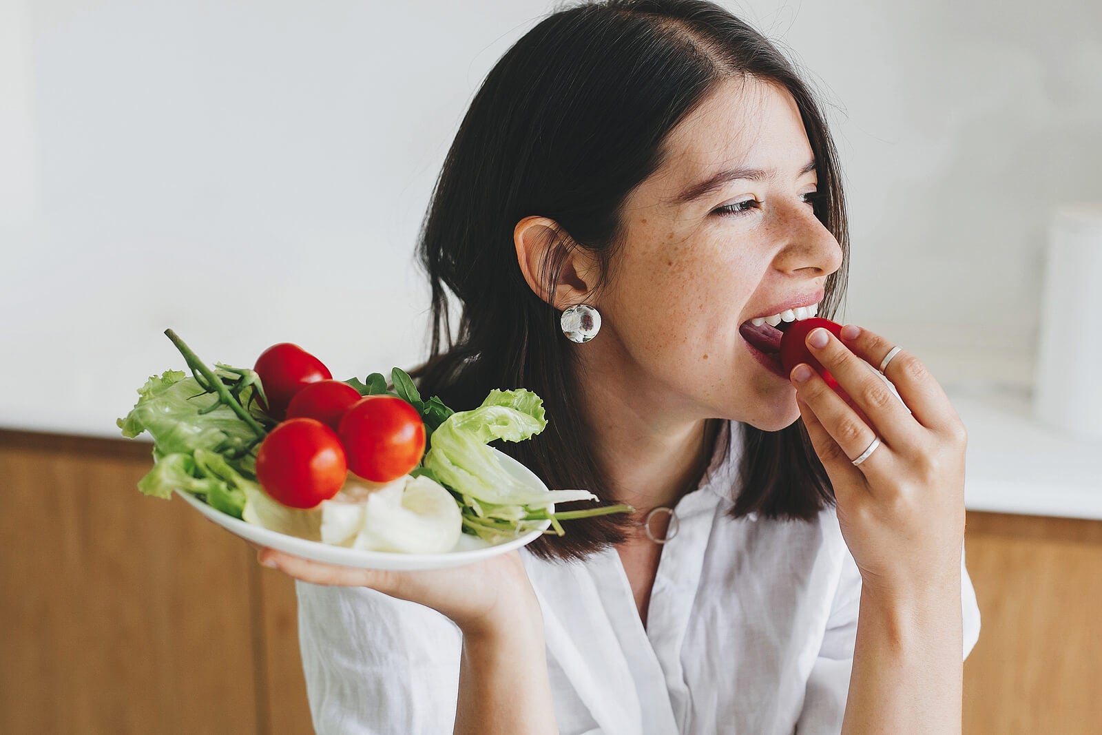 puffernde Lebensmittel - Frau isst eine Tomate
