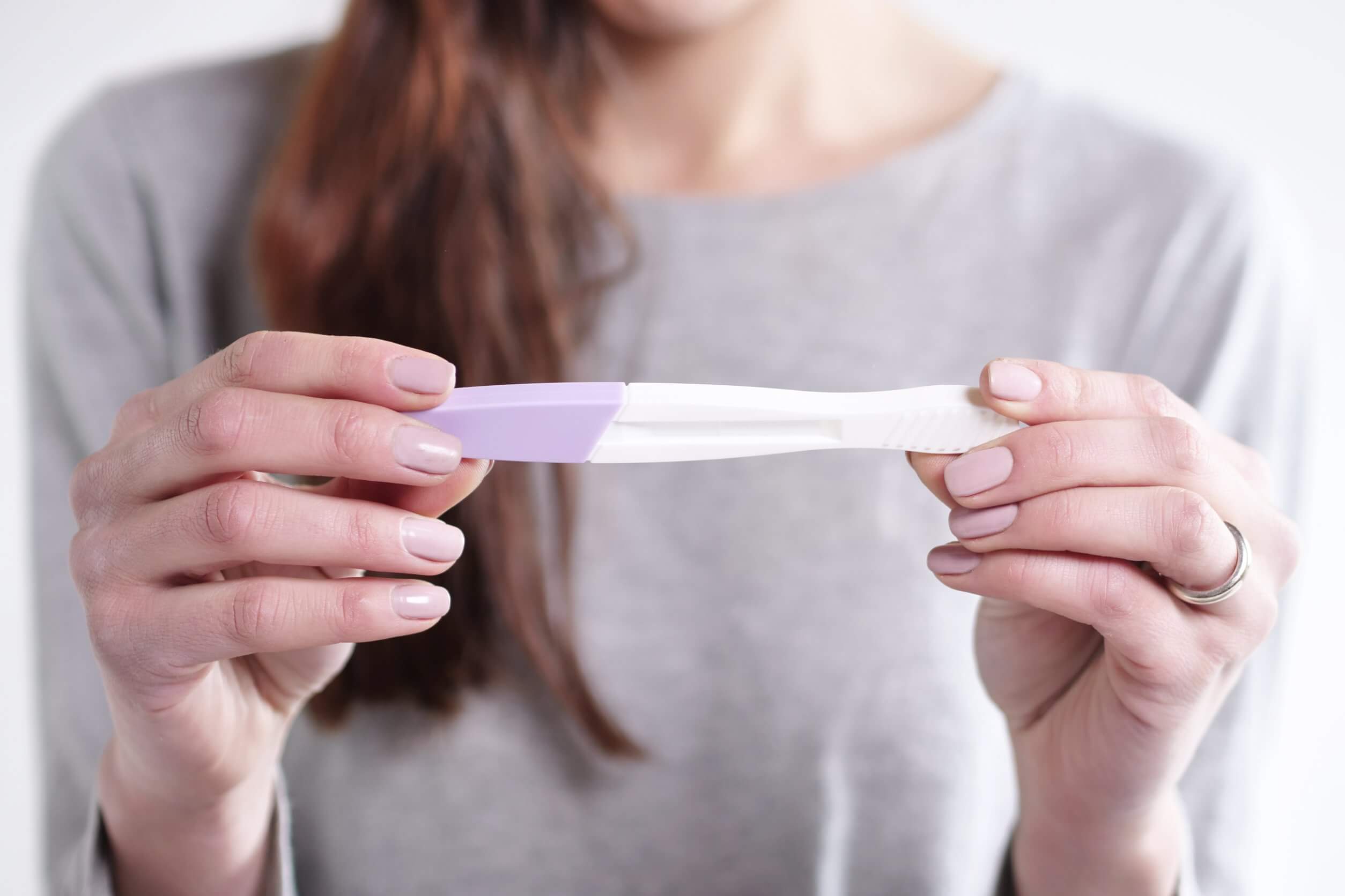 Embryotransfer - Frau mit einem Schwangerschaftstest