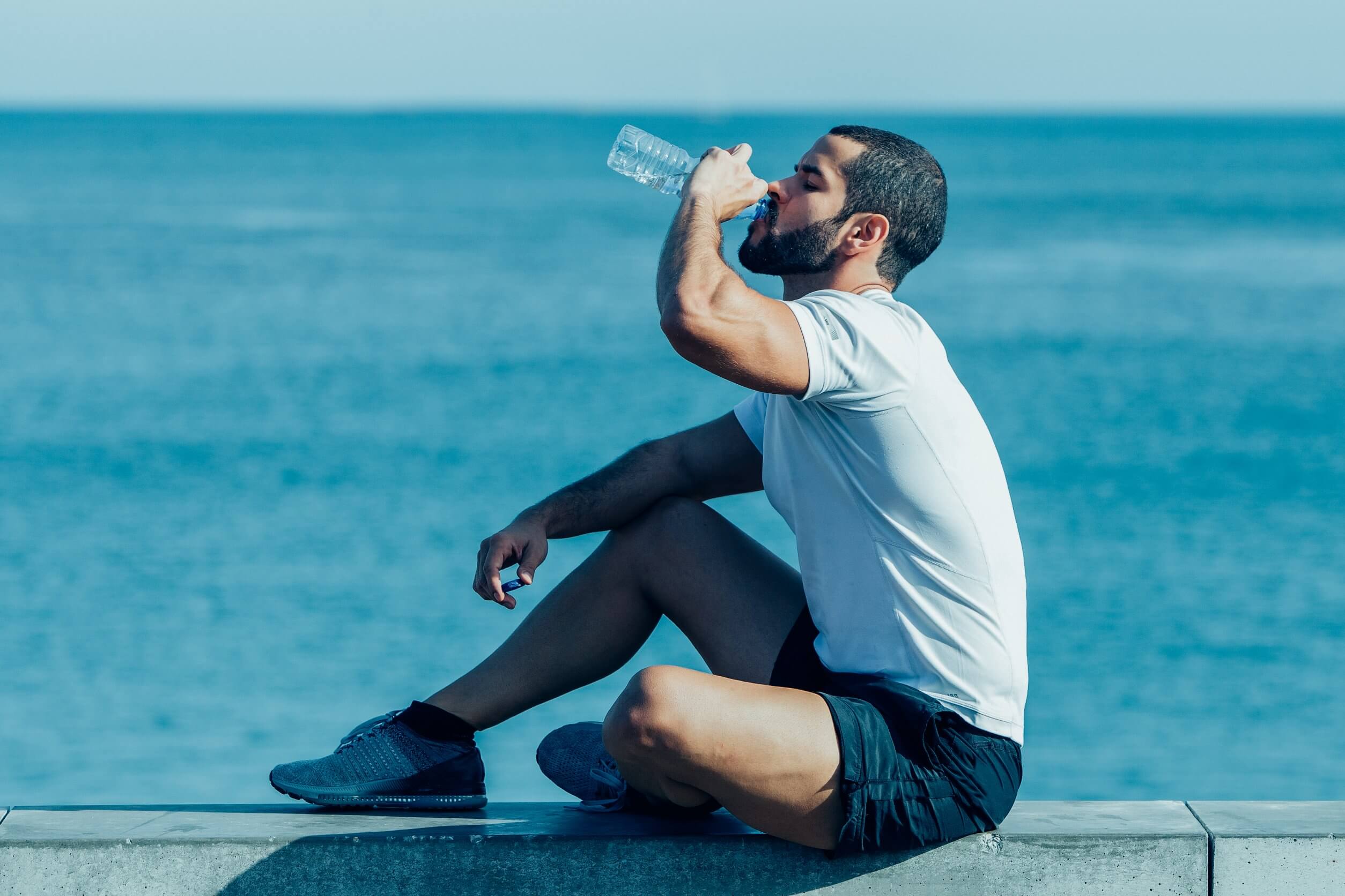Deportista tomando agua para no perder la hidratación