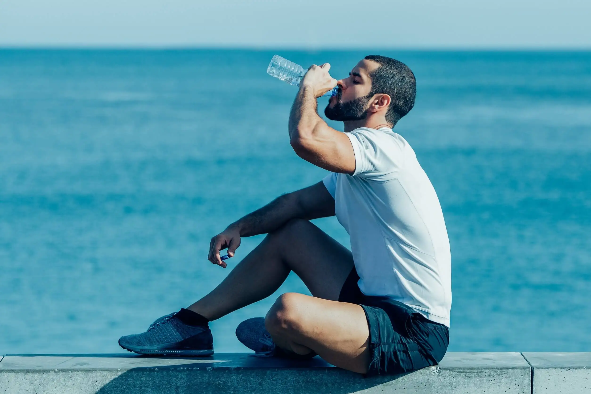 Deportista tomando agua para no perder la hidratación