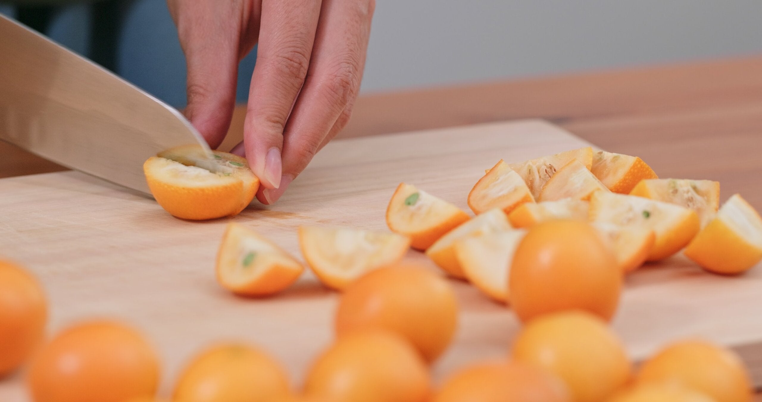 Halbierte Kumquats auf einem Holzbrett