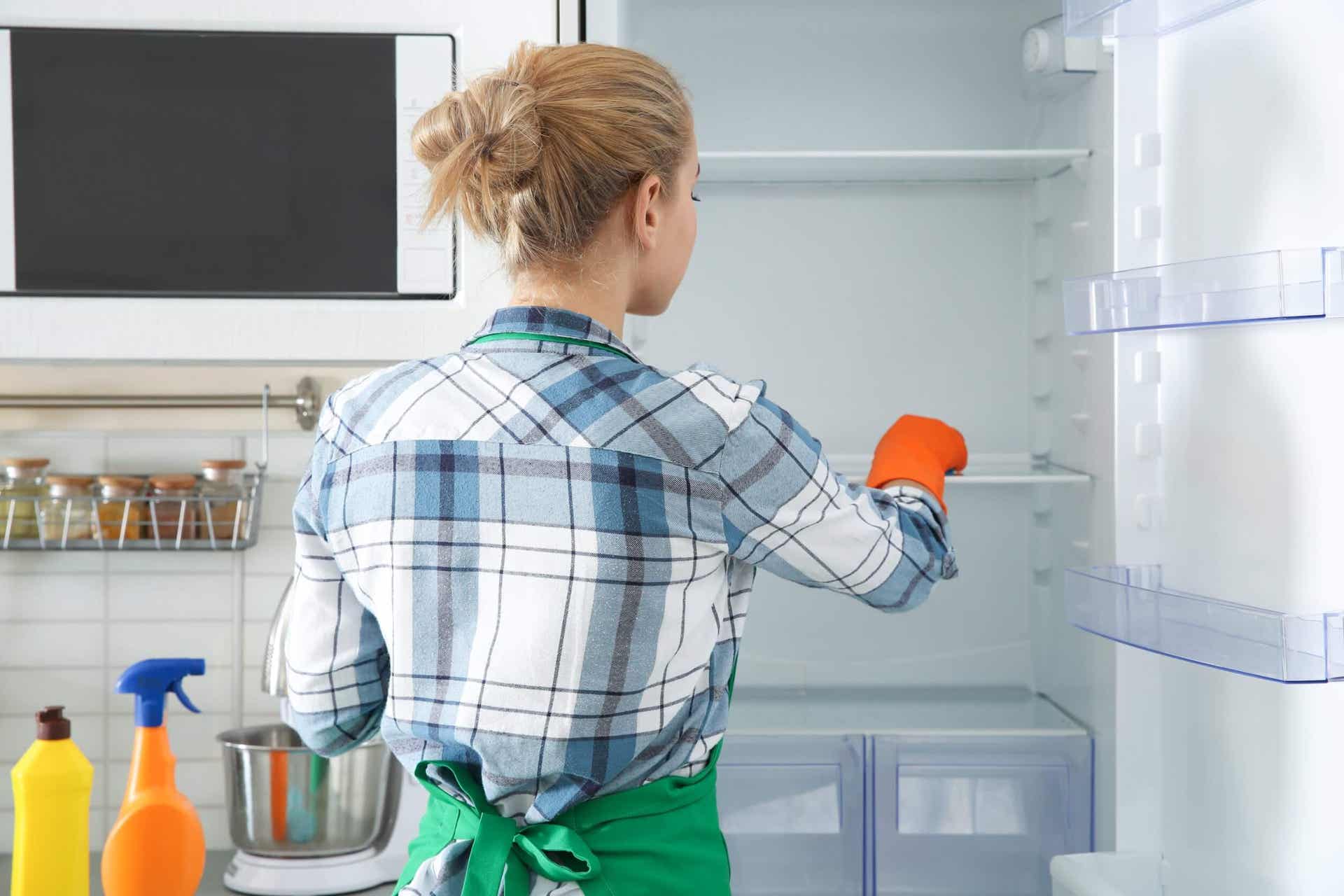 Putzen zum Stressabbau - Frau putzt den Kühlschrank