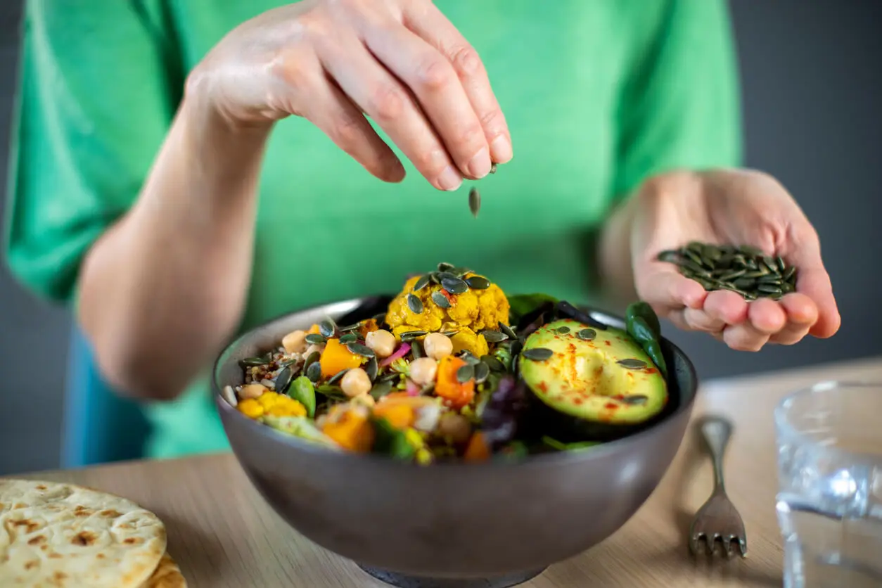 Fruchtbarkeitsfördernde Ernährung - Kürbiskerne auf einem Salat
