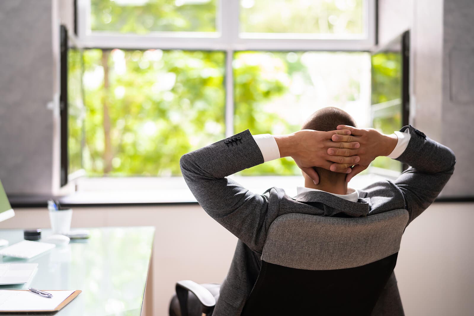 Man leunt achterover in zijn bureaustoel