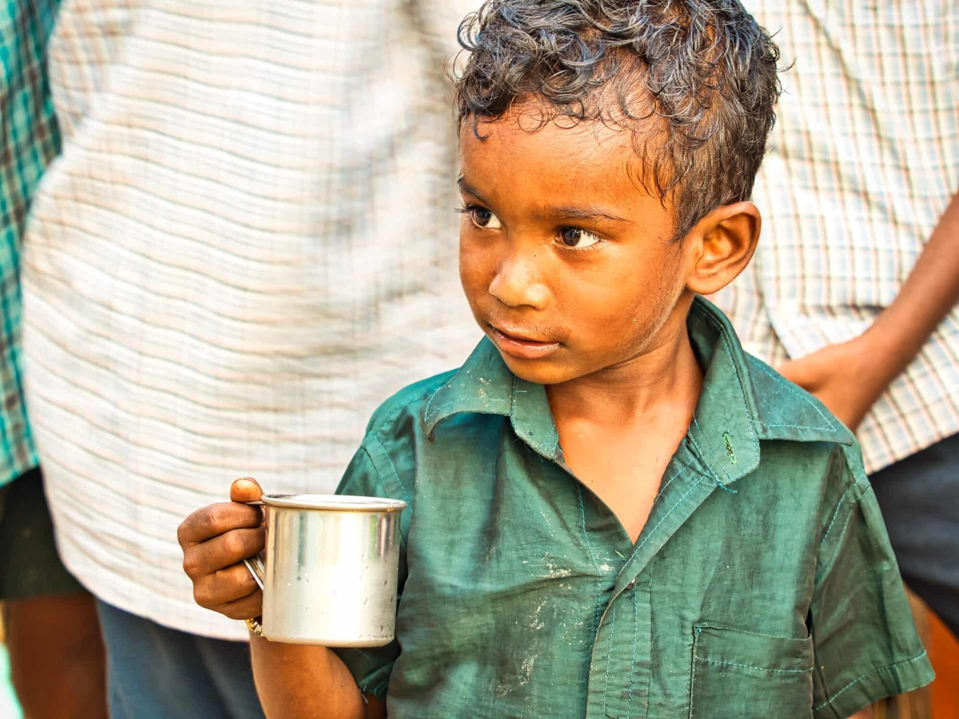 Welternährungstag - Junge mit einem Blechbecher in der Hand