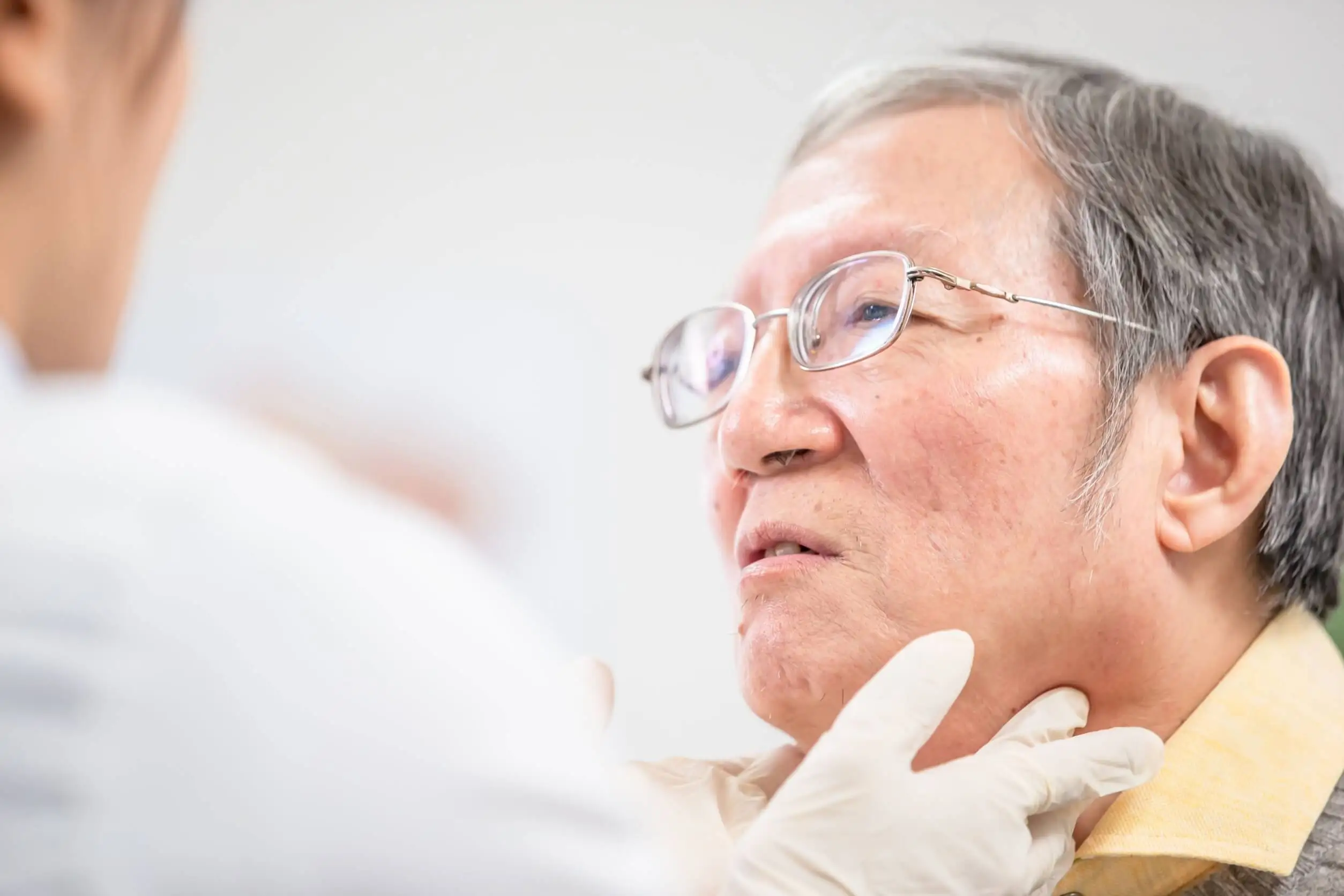 Dokter voelt aan de hals van een man