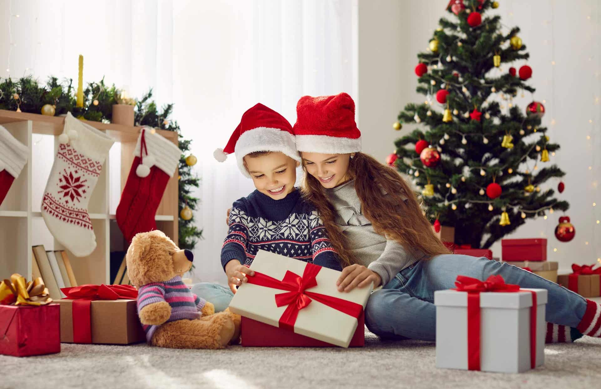 Dzieci otwierające świąteczne prezenty