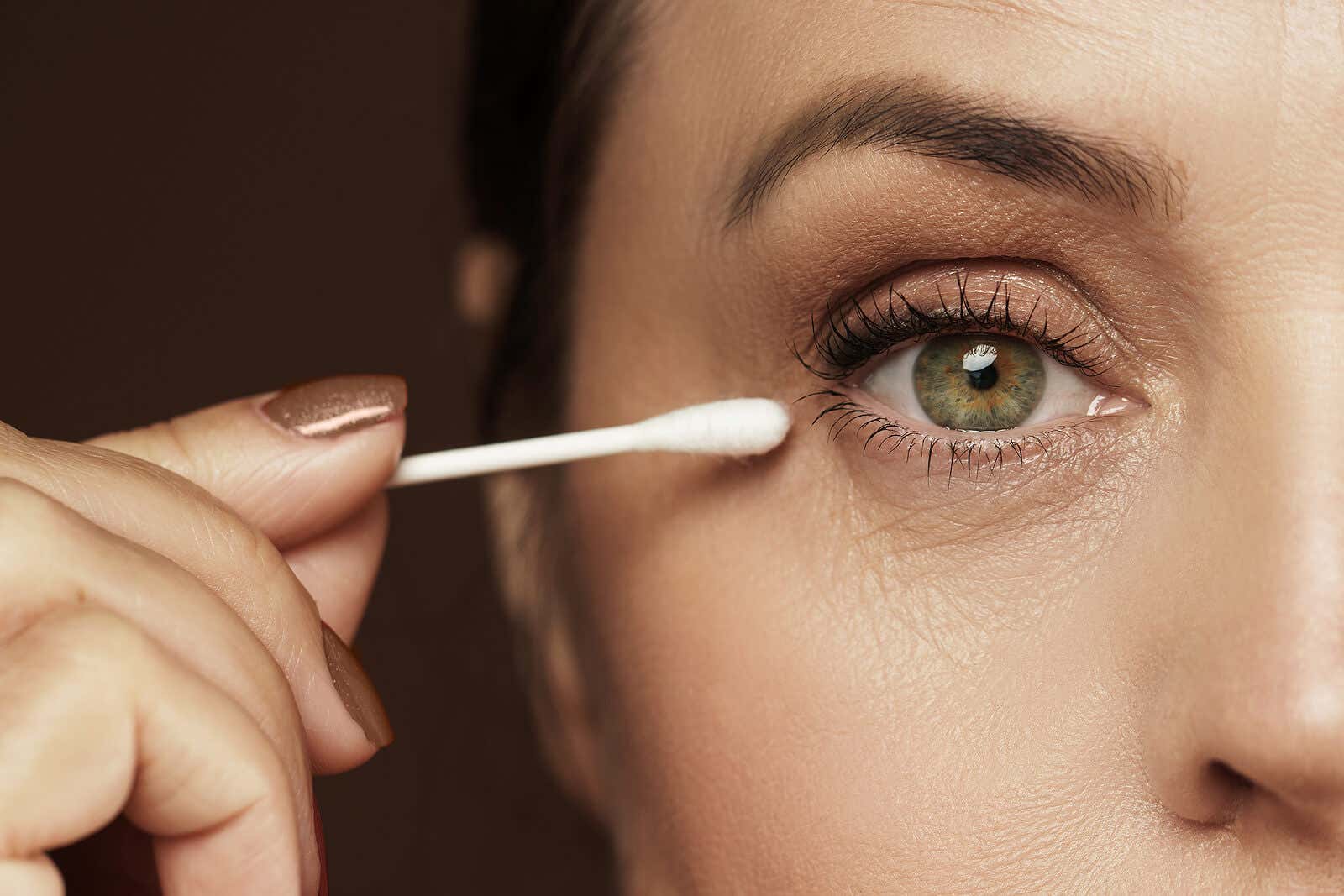 Make-up-Fehler bei Schlupflidern - Frau mit einem Wattestäbchen am Auge