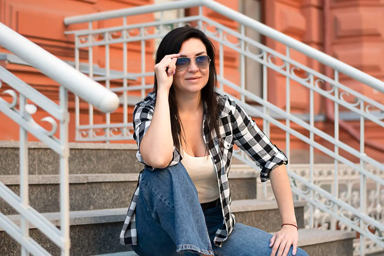 Mulher de camisa xadrez e estilo lenhador.