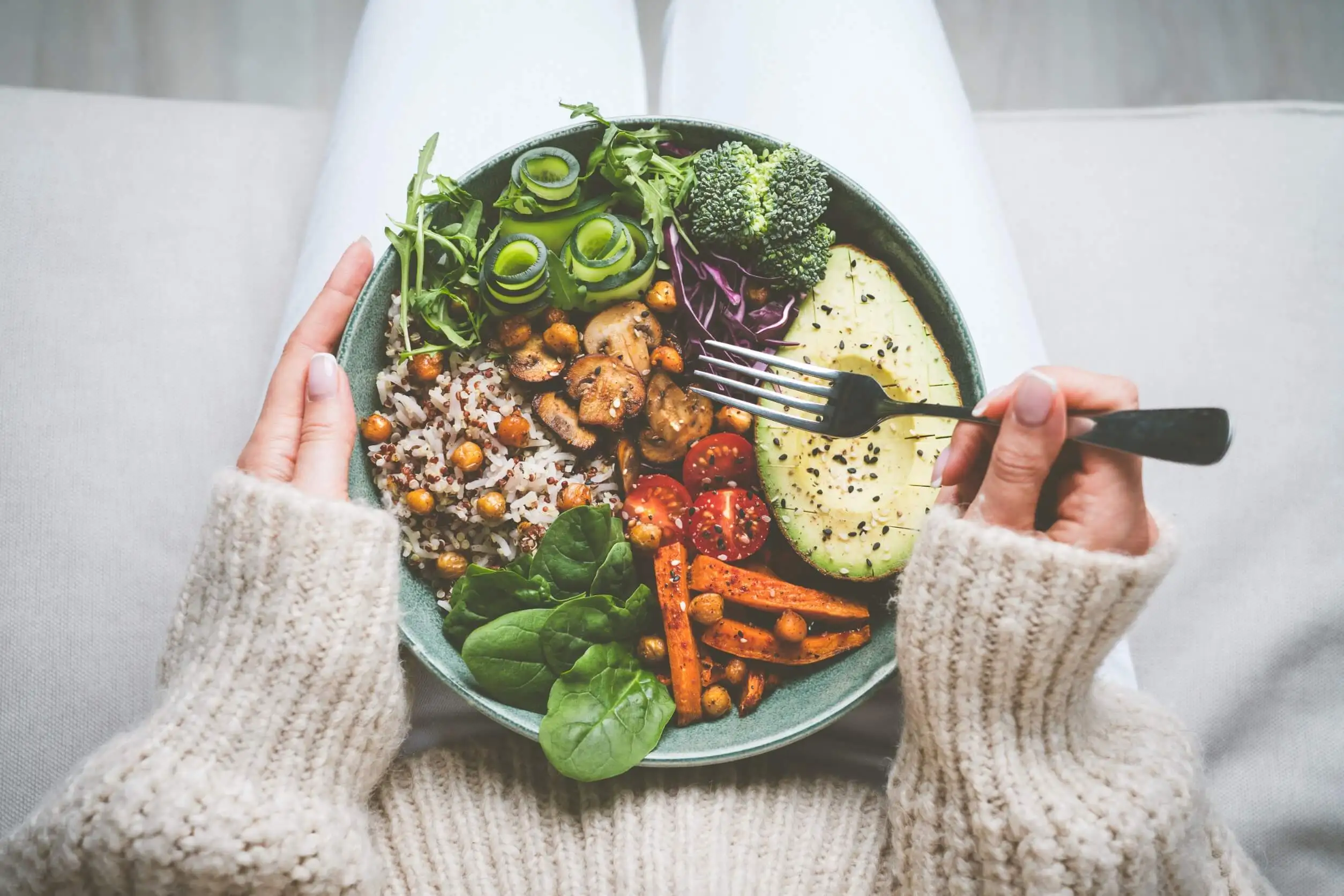 Mujer comiendo ensalada para aumentar la fibra en la dieta