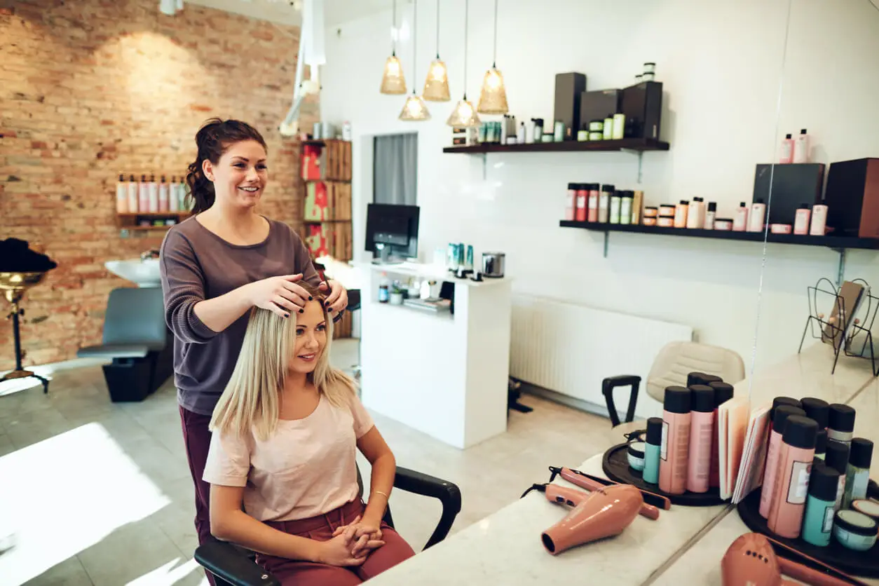 Estilista que hace corte smoky gold en una mujer.