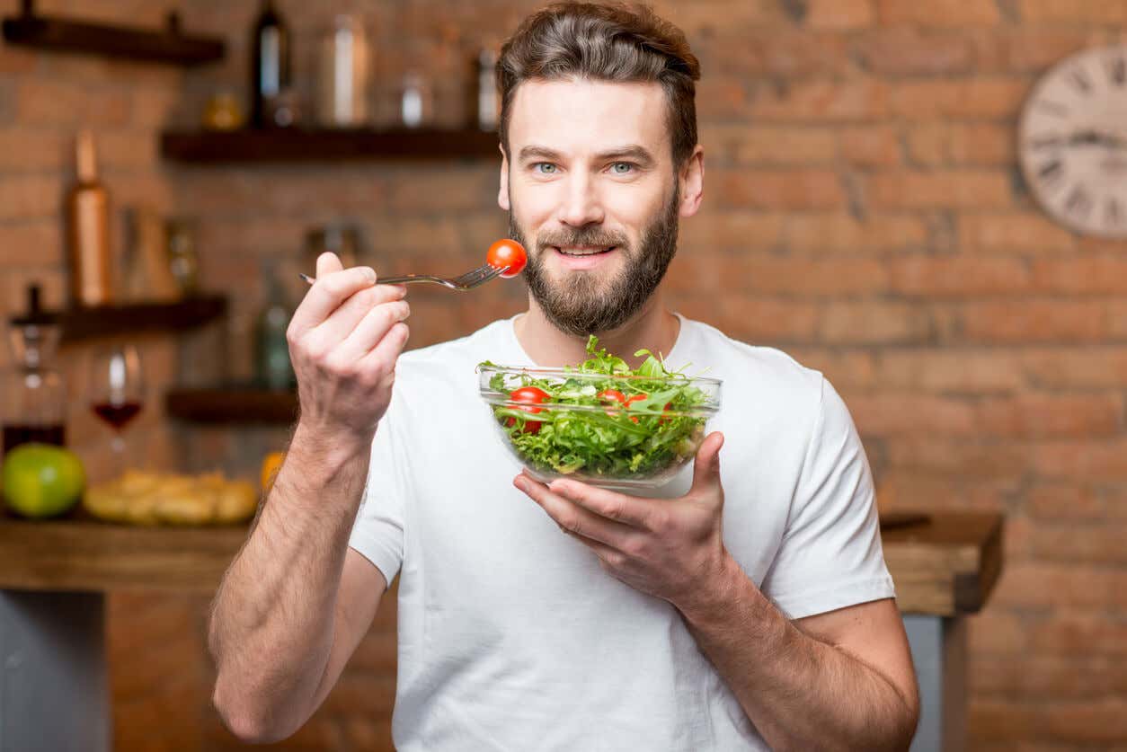 Mann som spiser salat.