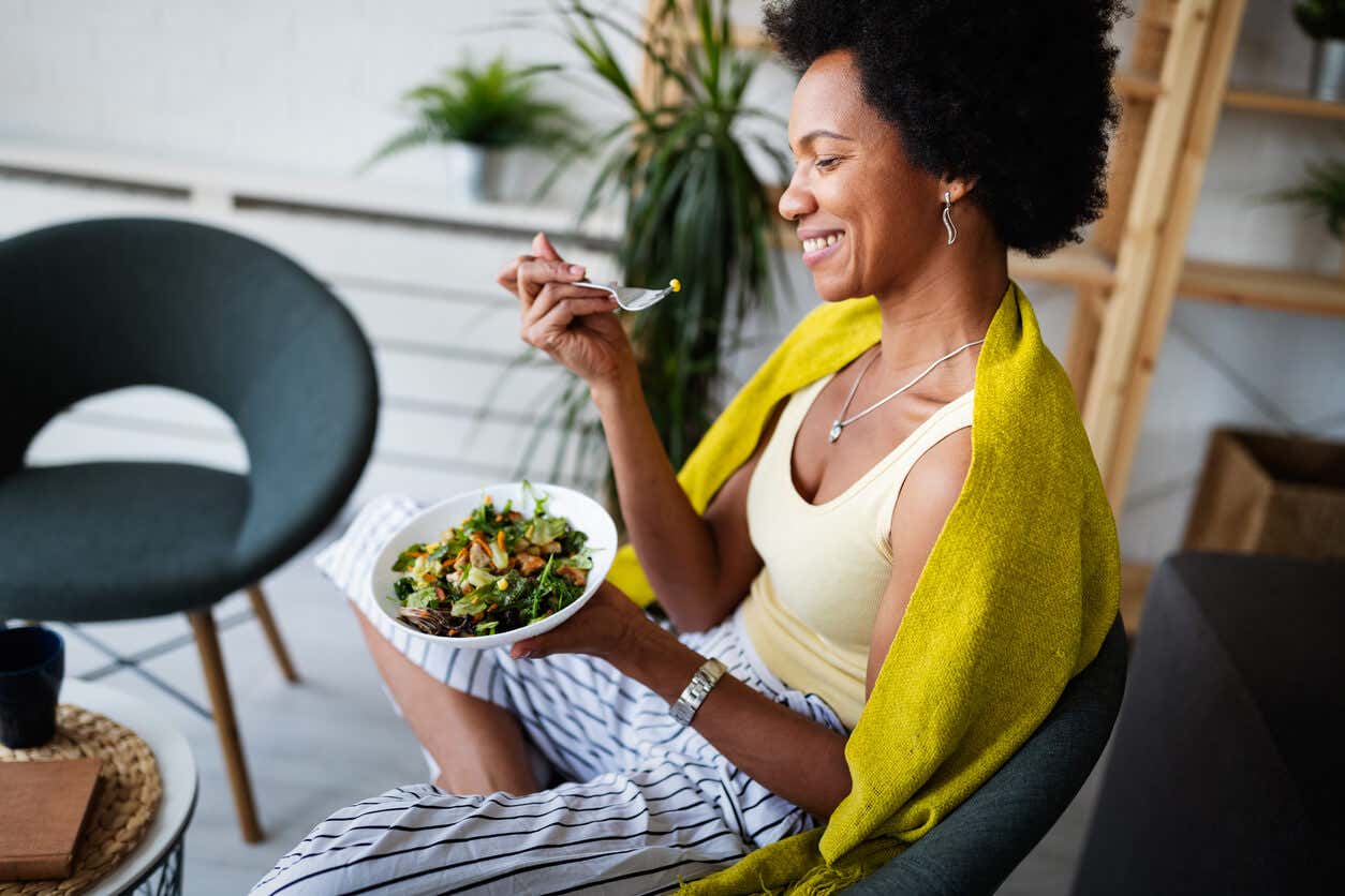 Mangiare in modo intelligente: donna mangia un piatto di insalata.