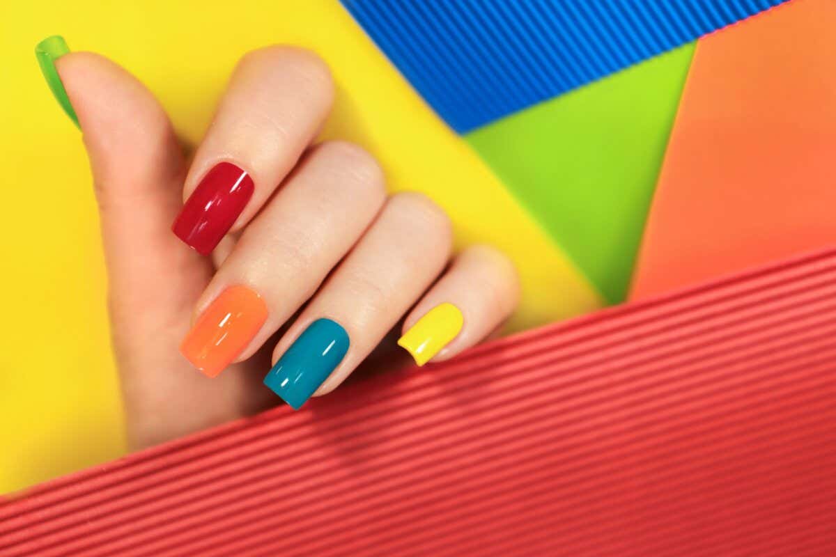 Lleva las uñas multicolor en tonos brillantes eller pasteller.