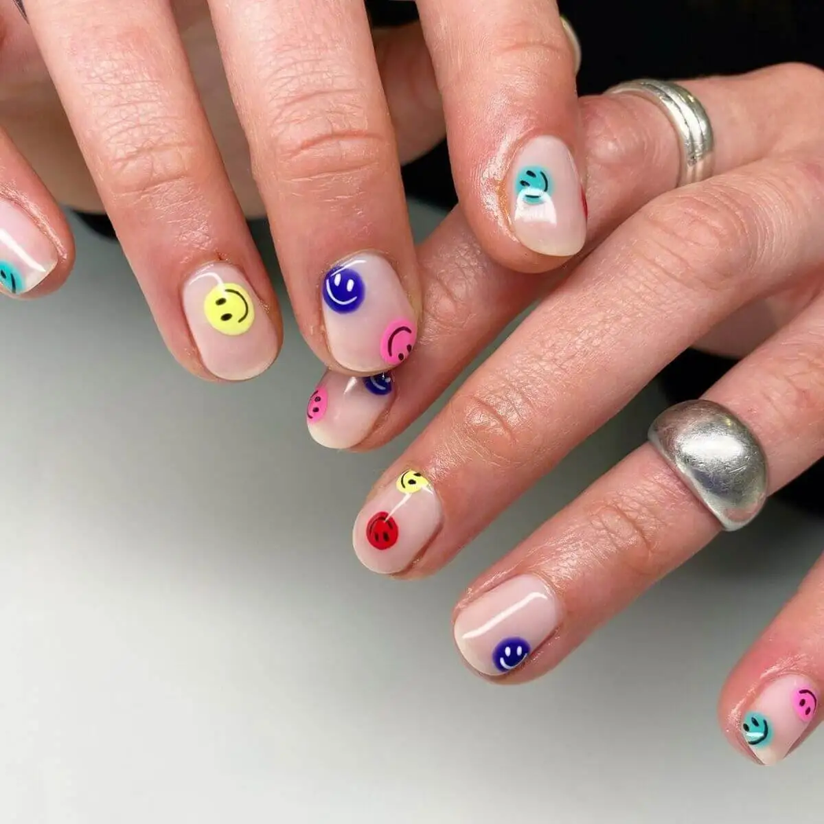 Diseño de uñas aesthetic con caras felices.