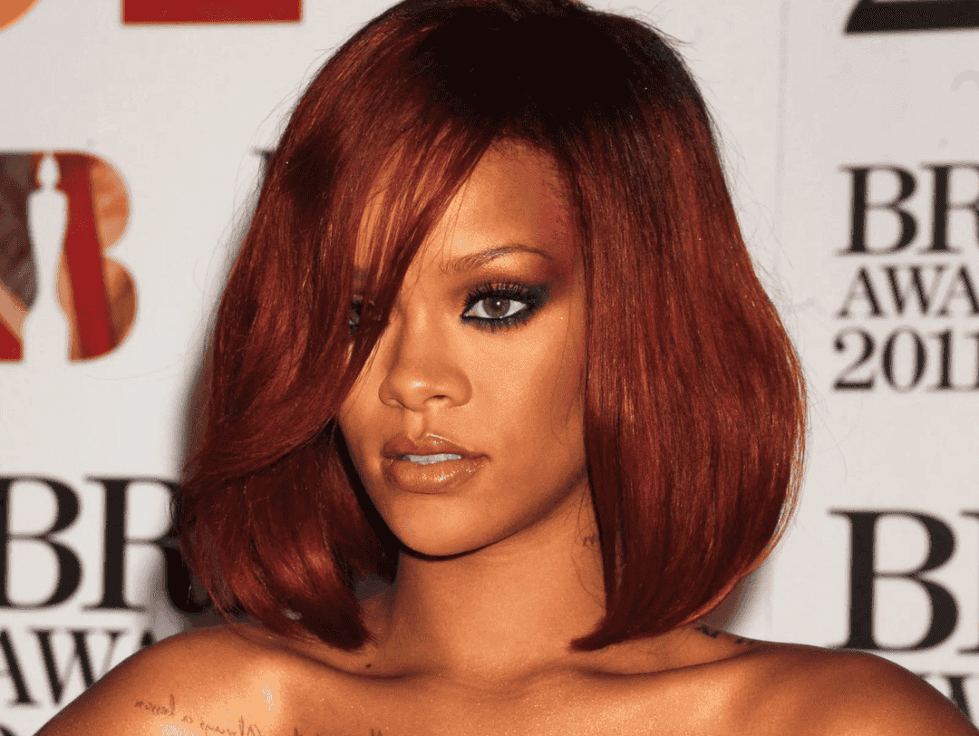 El rojo cereza de Rihanna es uno de los colores de cabello que lucen bien en la piel morena.