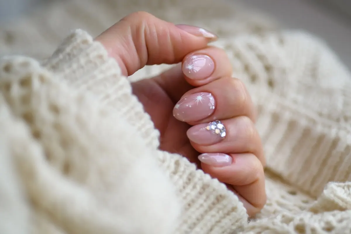 Diseño de uñas baby boomer con glitter y piedras.