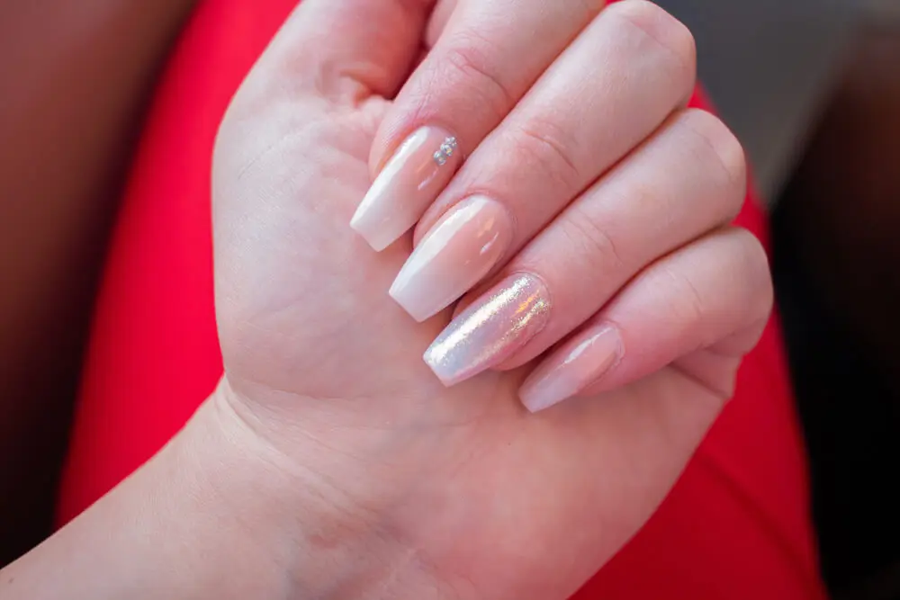 Diseño de uñas baby boomer sutil con piedras.