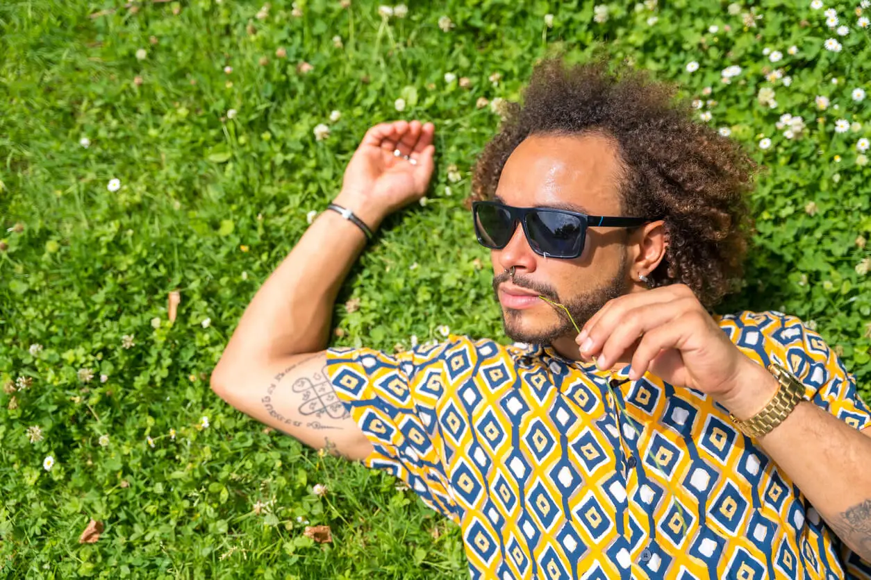 Hombre acostado en el césped posando