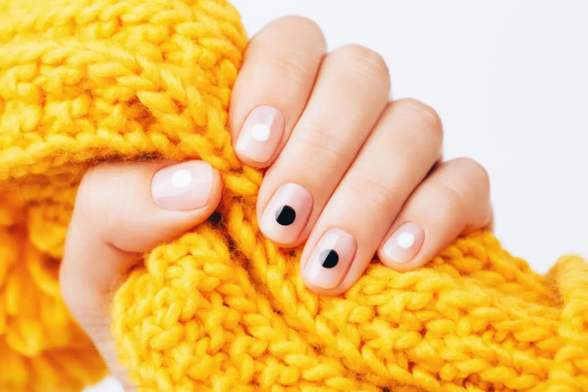 uñas con puntos blancos y negros.