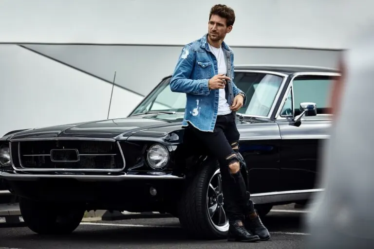 Hombre con chaqueta denim azul y pantalones negros.