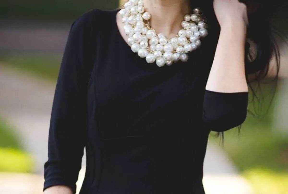 Vestido midi con collar de perlas.