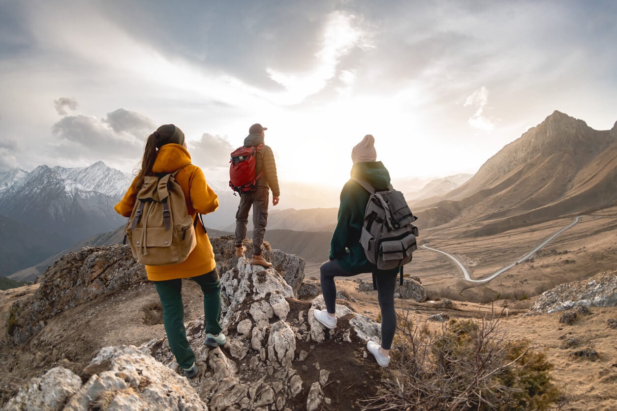 Tres amigos, con intereses comunes, en la cima de una montaña