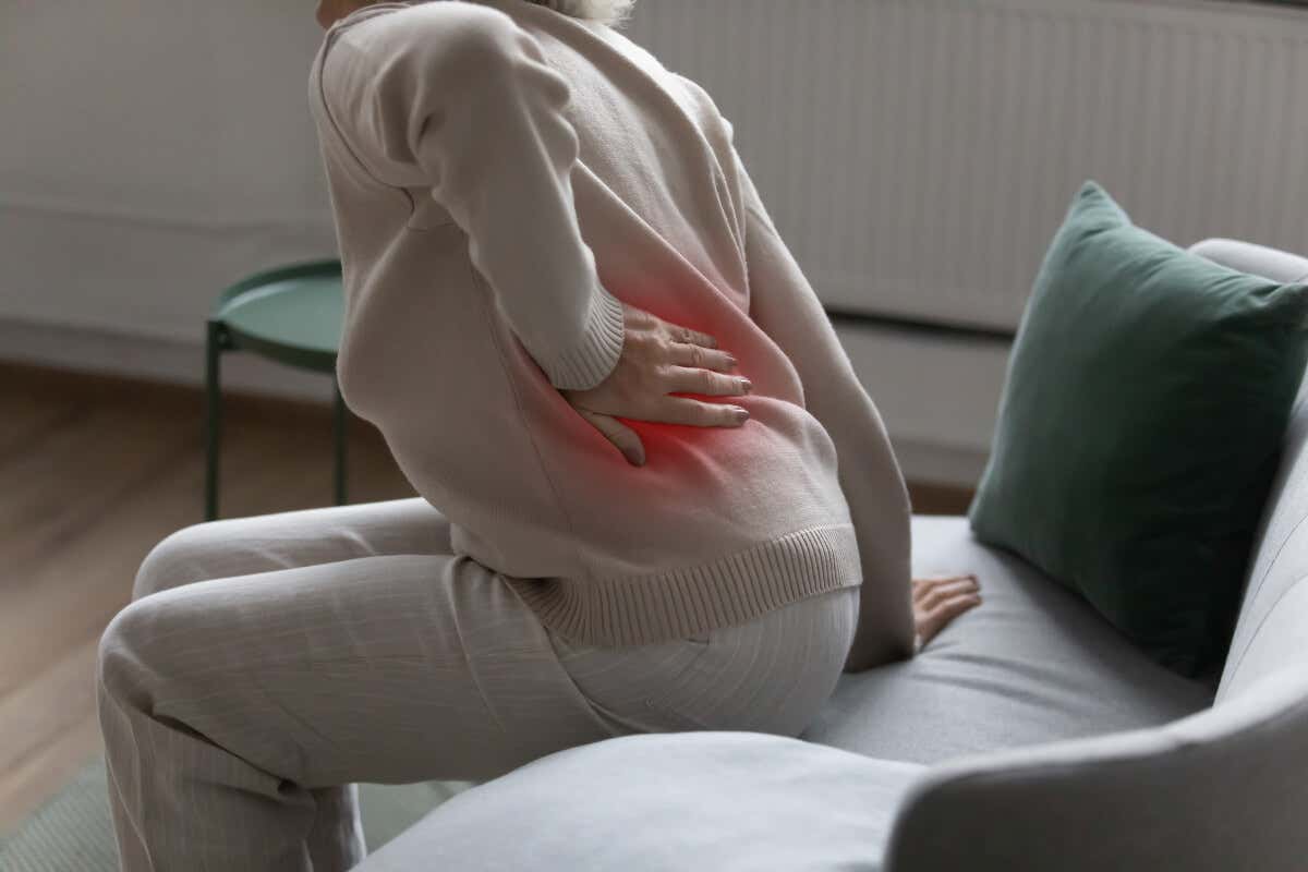 Mujer con dolor en la cadera a causa de la osteoporosis. 