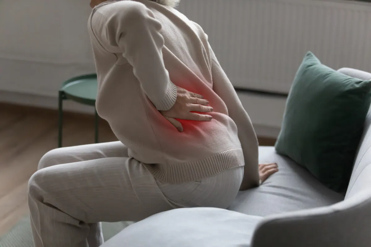 Mujer con dolor en la cadera a causa de la osteoporosis.