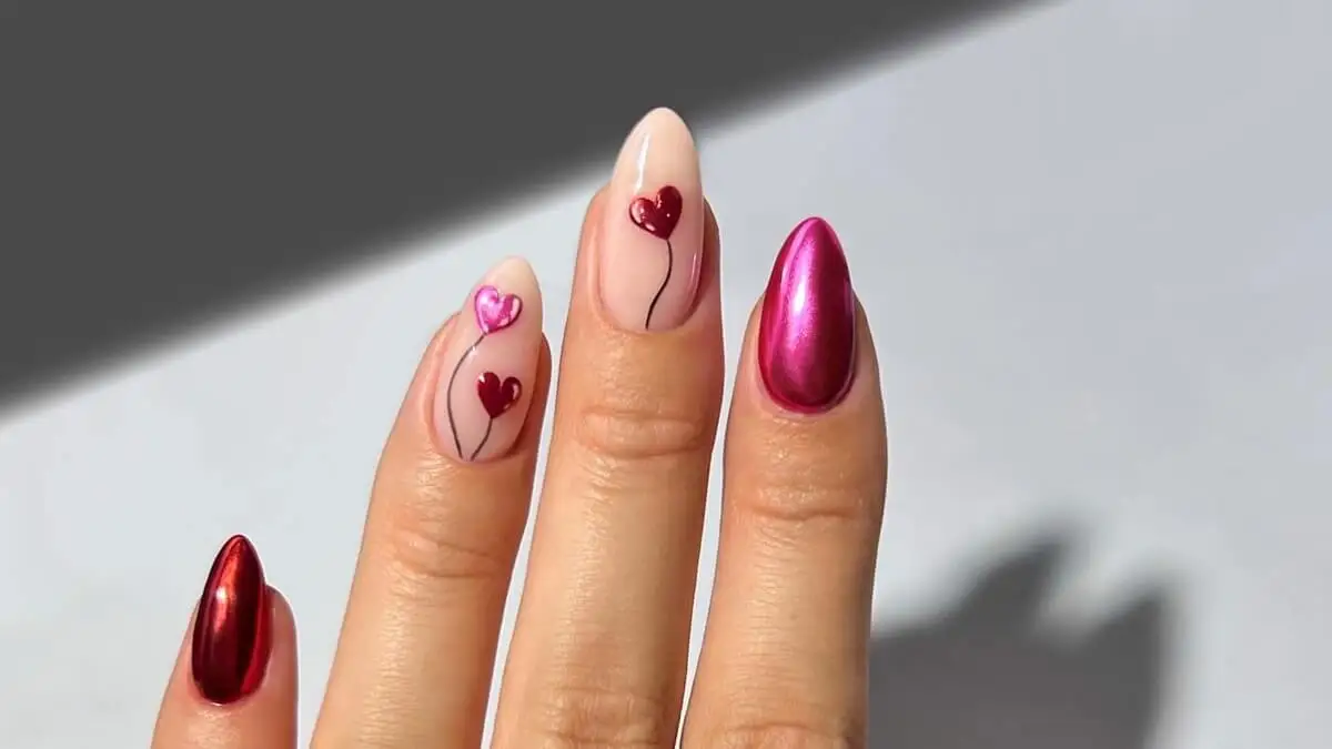 Unhas com desenho de balão em formato de coração.