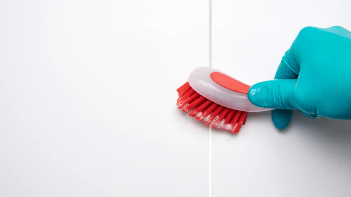 Limpieza de azulejos del baño con cepillo.